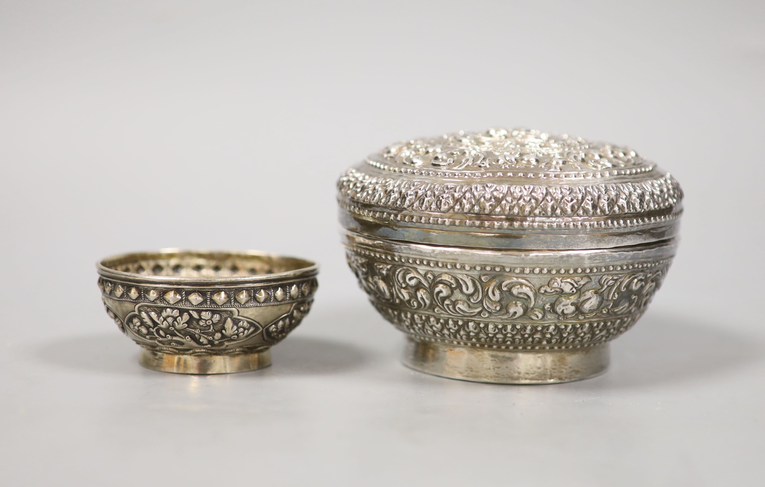 An Indonesian embossed white metal bowl and cover and two similar smaller bowls, largest diameter 13.5cm